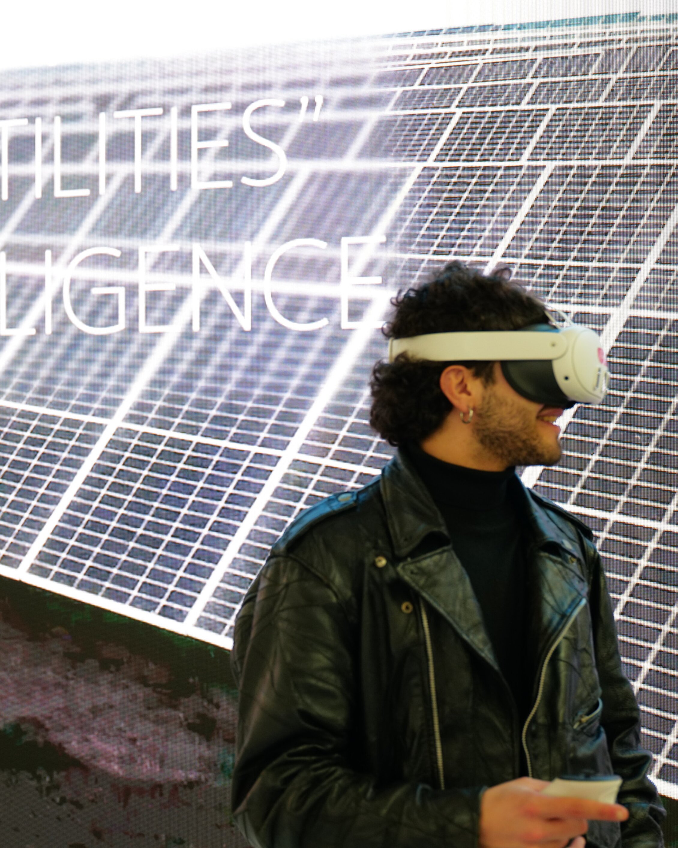 a man wearing a VR headset during KEY standing in front of a screen displaying solar panels