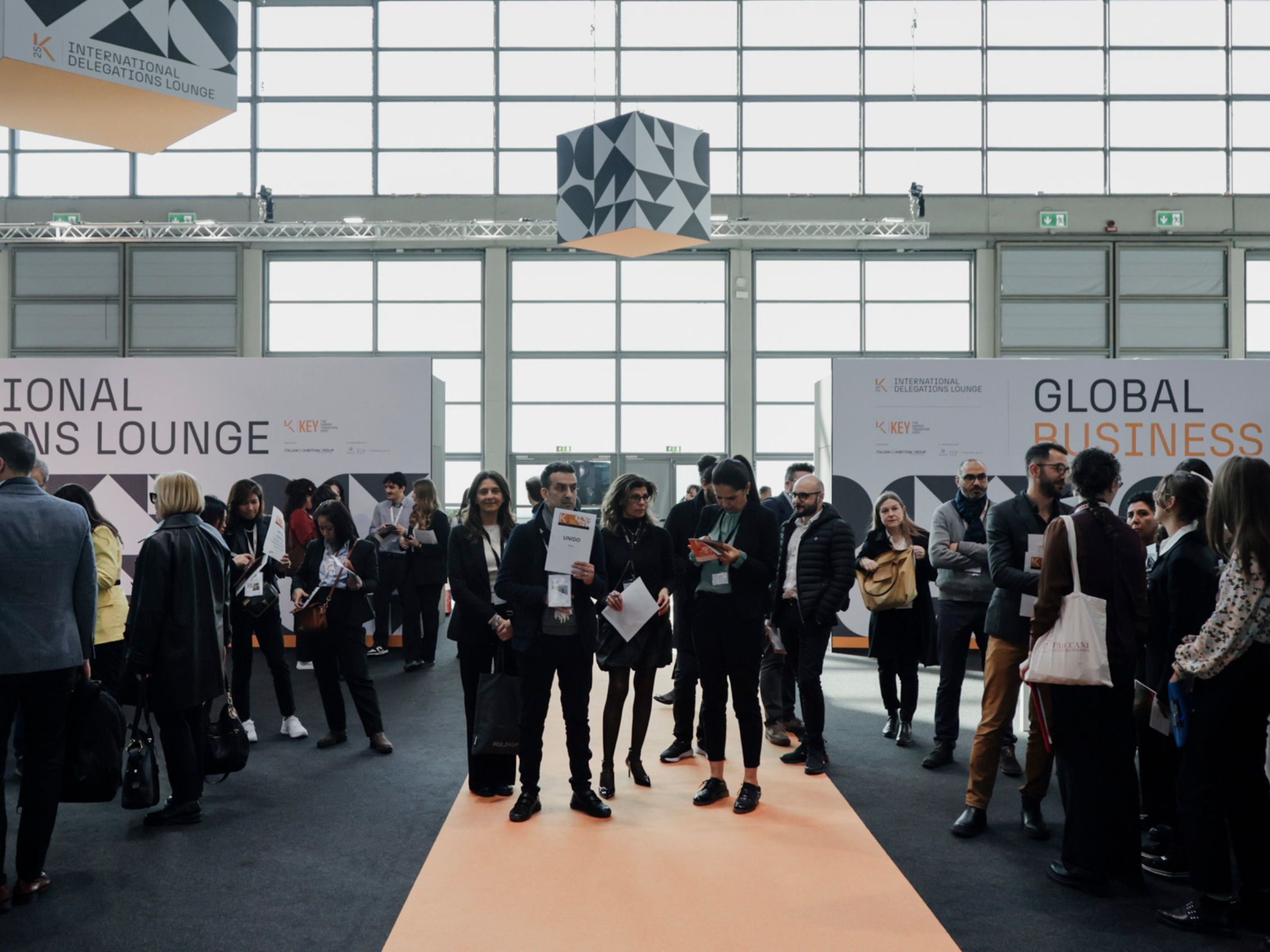Many visitors inside the International Delegations Lounge and the Global Business area during K.E.Y., engaging in conversations and reviewing informational materials