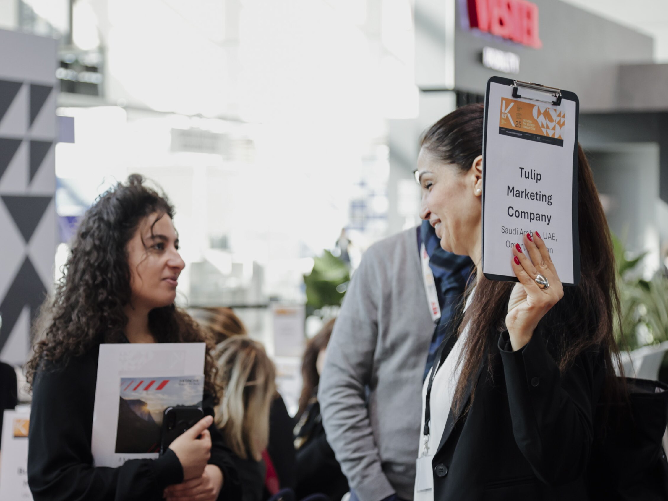 A representative of Tulip Marketing Company, specialized in marketing international exhibitions, is holding a sign with the KEY logo and the company name