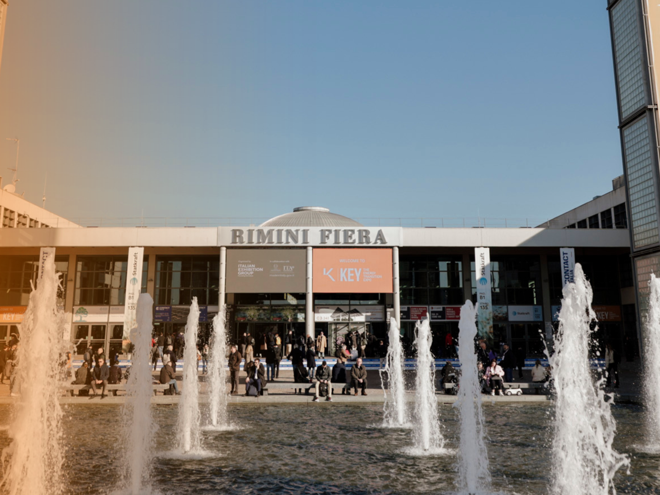 South entrance of the Rimini Expo Centre during K.E.Y., with fountains in the foreground and many visitors in front of the entrance