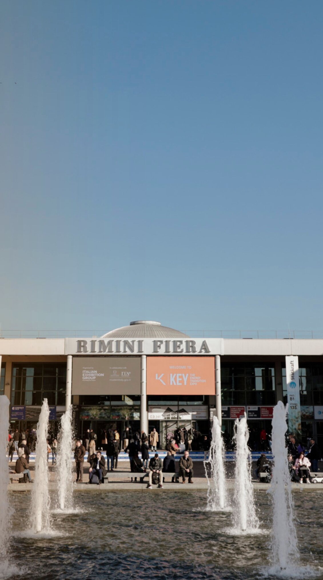 South entrance of the Rimini Expo Centre during K.E.Y., with fountains in the foreground and many visitors in front of the entrance