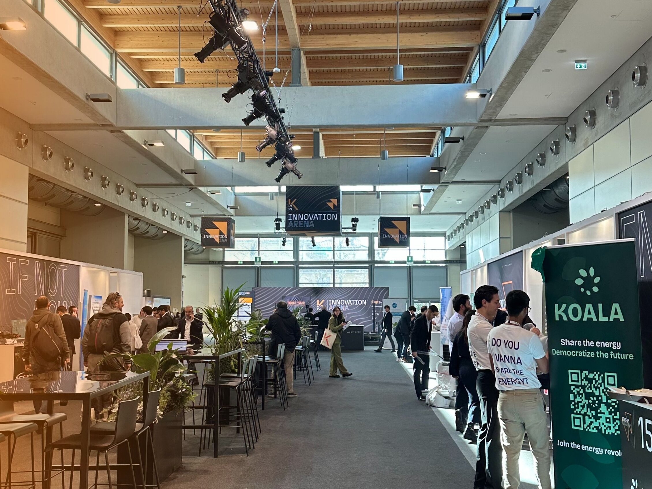  Interior of the Innovation District Area of ​​KEY The Energy Transition Expo with exhibit booths, people and signs